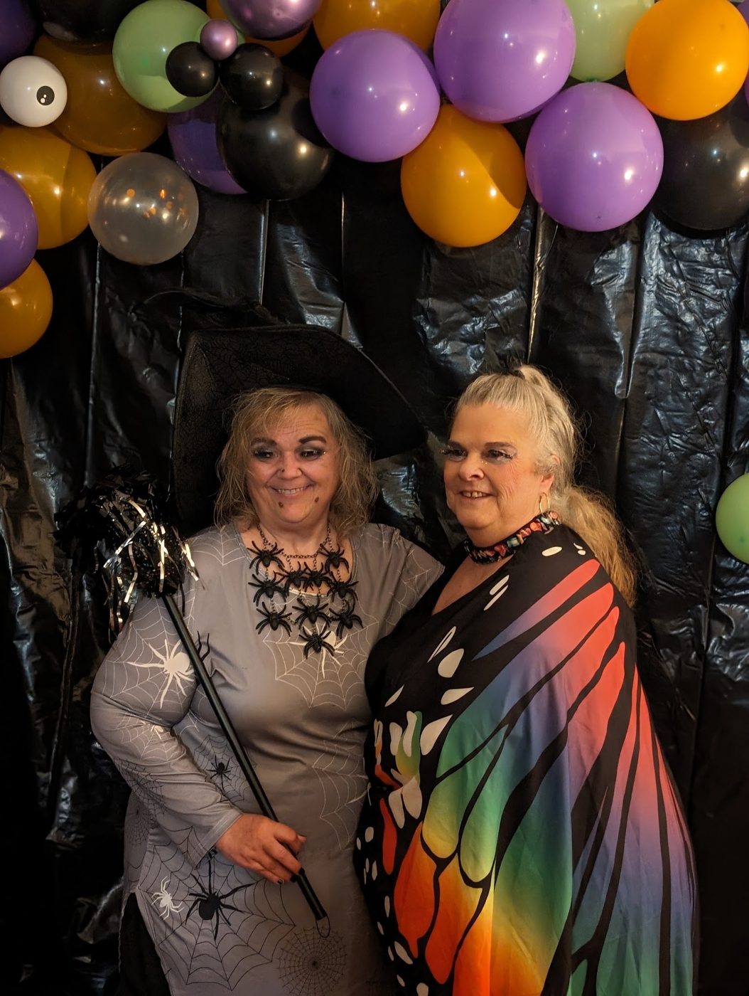 A witch and a butterfly by the balloon wall