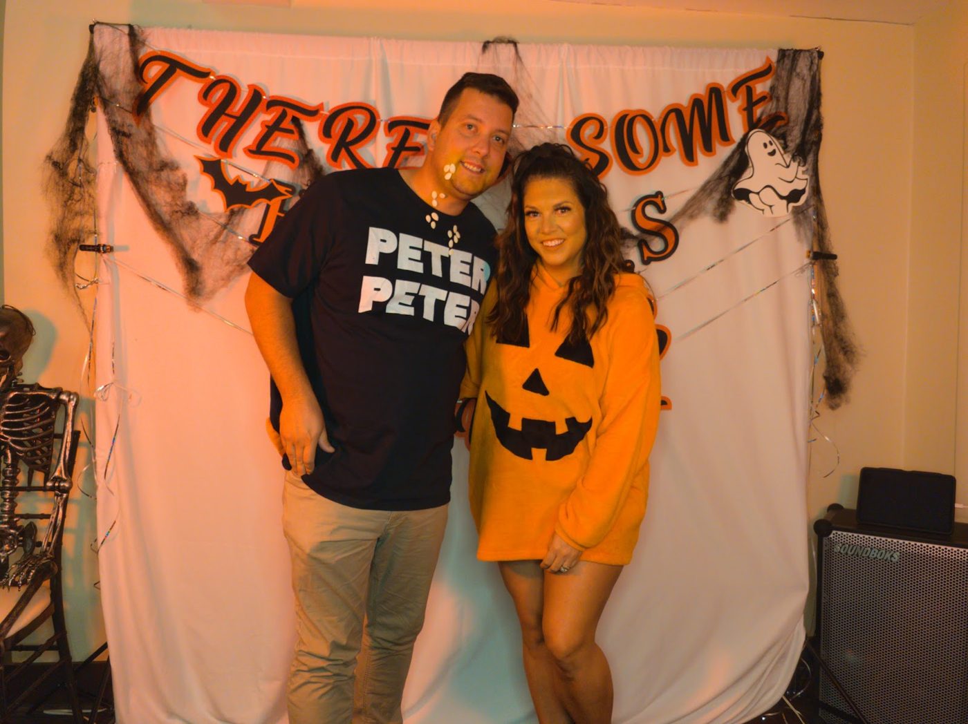 Peter Peter Pumpkin Eater and his pumpkin in front of a spooky banner