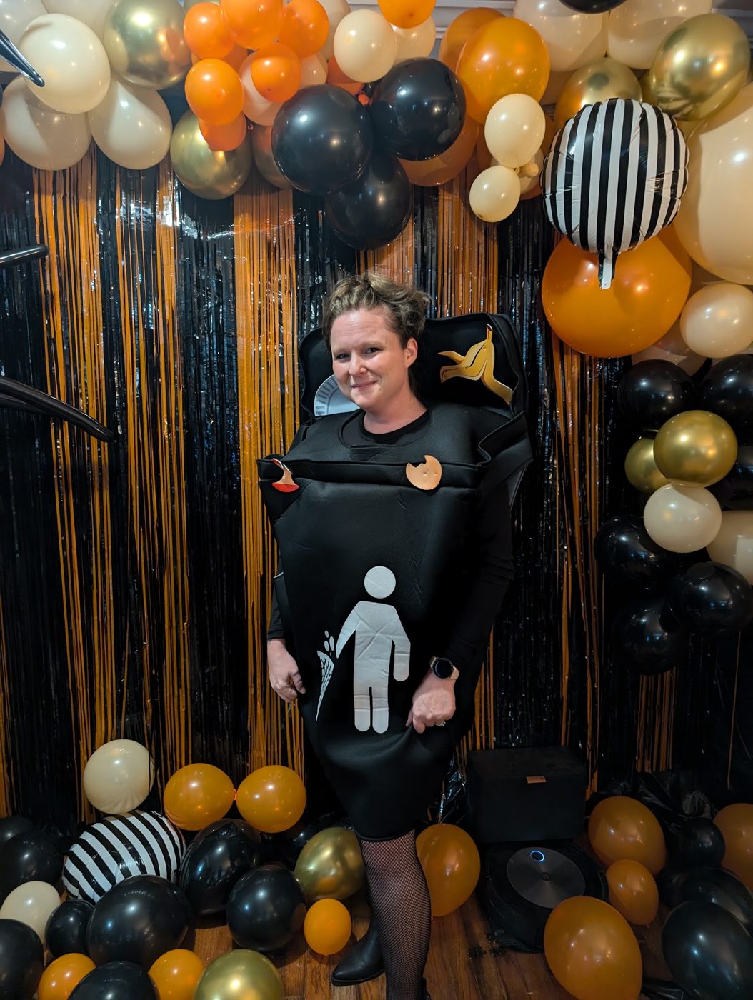 A guest dressed as a restroom sign under the balloons